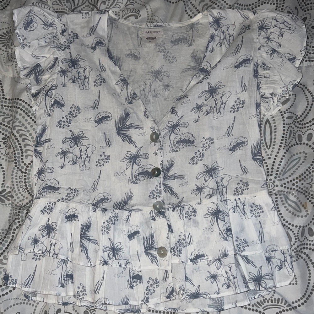 It’s a white blouse with elephants and palm trees